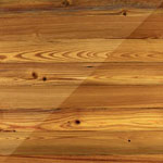 photo showing a swatch of heart pine with and without a finish